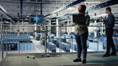 Endüstriyel platformdaki veri merkezi denetçisi yapay zeka sondaj işleme hızını geliştirmeye çalışıyor. Afro-Amerikan sunucu merkezi yöneticisi yapay zeka iş yükünü destekleyen ekipmanları denetliyor, kamera A