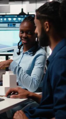 Dijital proje iç tasarım ve planlarını inceleyen Dikey Video Geliştiriciler ekibi, emlak geliştirme için yapıyı planlıyor. İnşaat alanının kat planları ve konut planları. Kamera.