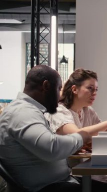 Dikey Video Çeşitliliği mühendisleri ekibi, masadaki yerleşim planı genişlemesi ve altyapı büyümesini görselleştirmek için 3D modeller kullanarak yapısal emlak şehir planlamasını gözden geçirir. Yenilik merkezi