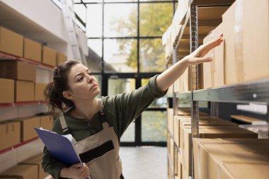 Küçük bir tesiste paket ve paletlerle çalışan, e-ticaret sevkiyat hizmetlerini destekleyen ve perakende ürünler için kalite kontrolü sağlayan kadın çalışanlar. Toptan kargo..