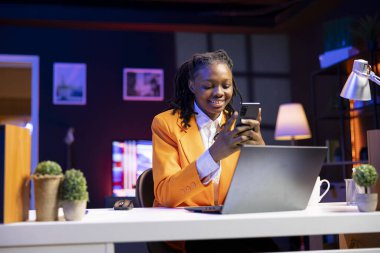 Evdeki mutlu kadın, çevrimiçi içerik yaratıcılarının canlı yayınlarıyla telefonda sosyal medyaya bakıyor. Etkilenenler tarafından yapılan canlı yayınlarla sosyal ağ uygulaması kullanan neşeli kişi