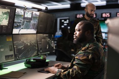 Askeri komuta merkezi olarak çalışan askerler ve dijital ekipmanlarla dolu gözetim merkezi. Operasyon üssünde görev yapan sevkiyatçılar