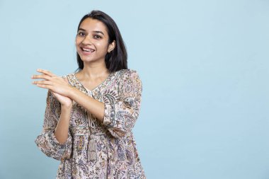 Stüdyoda birini öven ve alkışlayan Hintli kız. Tebrik ediyor ve hayranlıkla alkışlıyor. Genç memnun kadın zafer işareti yapıyor..