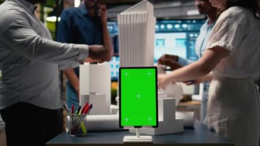 Mühendisler, üç boyutlu mimari modeller ve inşaat planları kullanarak kroma anahtar ekranının yanında ana plan fikirlerini paylaşıyorlar. Modern tasarım şehir planlaması. Kamera A.