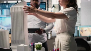 Sürdürülebilirlik ve kentsel altyapı büyümesi odaklı bir konut projesi için 3D modeller yapısal düzeni değerlendiren bir emlak geliştirme ekibi. İnşaat alanı için brifing toplantısı. Kamera B.