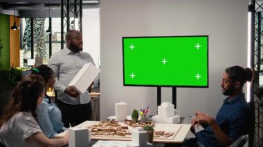 Mülk mühendisleri ekibi, kentsel kalkınma ana planında işbirliği yaparak, TV 'de bir modelle mimari planlar üzerinde çalışıyor. Altyapı hedefleri olan modern konut projesi. Kamera A.