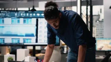 Ortadoğulu emlak müteahhidi, altyapı büyümesi için kentsel konut projesi üzerinde çalışarak dizüstü bilgisayarın inşaat alanı planlarını değerlendiriyor. Akıllı şehir için yapısal tasarım. Kamera B.