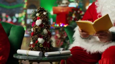 Noel Baba çocuk romanı okuyor. Samimi bir odada süsleri, Noel ağacı, çorapları ve şöminesi var. Tatil sezonunda çocuklara kitap okuyan yaşlı bir adam, kamera A.