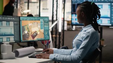 Siyahi kadın uzman bir yazılımın iç tasarımı ve duvar yapısı üzerinde çalışarak emlak inşaatı projesi için bir düzen oluşturuyor. Kentsel gelişim için altyapı büyümesi. Kamera B.