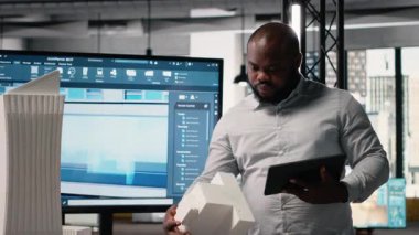 Afrika kökenli Amerikalı emlak müteahhidi arazi edinme ve inşaat planlamasına odaklanıyor, akıllı şehir ve altyapı büyümesi ile uyumlu proje planlarını gözden geçiriyor. Yenilik merkezi. Kamera B.