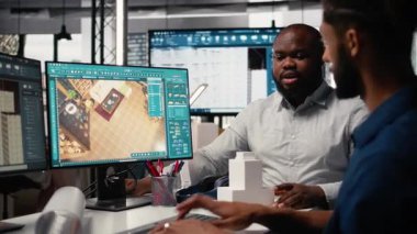 Mühendis ve tasarımcı, profesyonel düzen ve yapı için yazılım kullanarak gayrimenkul iç tasarımı üzerinde birlikte çalışıyorlar. Büyük planlar yapmak ve inşaat planlarını gözden geçirmek. Kamera A.