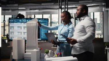 Müteahhitler ekibi kentsel kalkınma için yapısal 3D modeller planını gözden geçirir, gayrimenkul hedefleri ile şehir planlamasının sürdürülebilirliğini dengeler. Site hazırlığı. Kamera A.