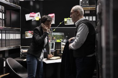 İki dedektif ekibi, bir soruşturmada bilgi paylaşmak ve kanıtları çapraz kontrol etmek için telekomünikasyon araçlarını kullanarak polis merkeziyle bir telefon görüşmesi yapıyor..