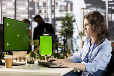 Young administrator reviewing company data next to copy space display, solving resource allocation to achieve effective business operations. Woman does financial forecasting and data analysis.