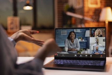 Closeup of ongoing video call on device screen as black woman participates in business conversation with coworkers. Female freelancer discussing with potential clients during virtual meeting on laptop