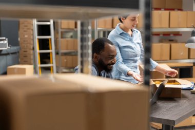 Lojistiğe ve ürün taşımaya odaklanan iki farklı çalışan, depo raflarında bantlanmış kutularla çalışıyorlar. Yerel bir perakende dağıtım hizmeti için sipariş tamamlama.