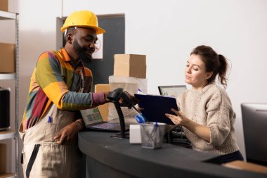 Colleagues checking the inventory list on clipboard before processing the orders, preparing packages and handling logistics for distribution. Product retail delivery for online shopping.