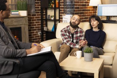 Erkek arkadaş ve kız arkadaş, özel klinikte siyahi erkek terapistle ilişki danışmanlığına katılıyor. Kafkasyalı çift el ele oturup Afrika kökenli Amerikan danışmanından profesyonel rehberlik istiyor.