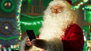 Noel Baba rolü yapan adam, çocukların cep telefonuyla hediye istemelerine tepki veriyor. Işıkla aydınlatılmış sakallı Noel Baba çocuklara Noel için ne istediklerini soruyor telefon ve kamera A 'yı kullanarak.