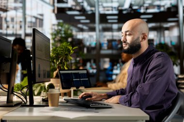 Ortadoğulu erkek analist ofiste proje geliştirme, mali planlama ve mali strateji üzerinde çalışıyor. Çalışan, iş merkezindeki işletmeleri yönetir..