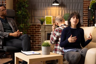 Afrika kökenli Amerikalı psikologla yapılan evlilik terapisi, beyaz bir çiftin ilişki sorunlarını tartıştığını gösteriyor. Karı koca sırt sırta oturur, danışmanlık sırasında duygularını paylaşırlar..