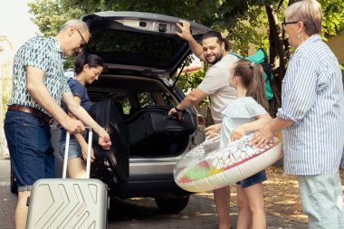 Büyükbabalar oğullarına ve gelinlerine yardım ederken küçük bir kız neşeyle seyrediyor, büyük bir grup aile deniz kenarına kaçacak diye heyecanlanıyor. Yolculuk yaşam tarzını rahatlatıyor..