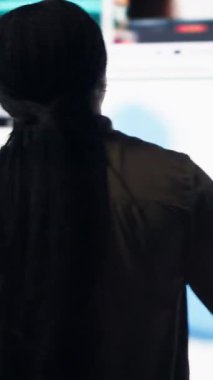 Vertical video Woman amazed by multitude of trending online videos feed on digital platforms. Person mesmerized by virtual video wall featuring global channels streaming dashboard with viral clips