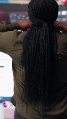 Vertical video Woman embraces abundance of video content displayed on digital wall dashboard, exploring entertainment channels. User amazed by immersive streaming platform delivering nonstop videos