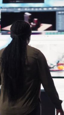 Vertical video Woman amazed by multitude of trending online videos feed on digital platforms. Person mesmerized by virtual video wall featuring global channels streaming dashboard with viral clips