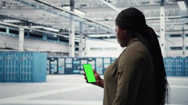 İşçi, sunucu merkezi enerji tüketimini kontrol etmek için model telefondaki uygulamayı kullanıyor. Güç yönetimi çözümlerinin uygulanması hakkında talimatlar almak için veri merkezinde yeşil ekran akıllı telefonu kullanan yönetici. Kamera A