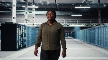 Admin walking in data center, overseeing large scale IT infrastructure to maintain seamless operations. Server farm employee doing network management for increased uptime, camera A