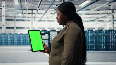 Hatasız ana bilgisayar ağlarını sağlamak için yeşil ekran tableti kullanan veri merkezinde yazılım geliştirici. Hatalar için sunucu merkezi dişli parçalarını izlemek için kadın model aygıtı kullanır, kamera A