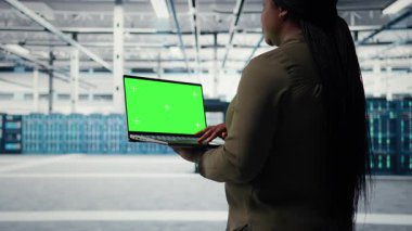 Technician in data center using isolated screen laptop to deploy new server architecture. Server hub worker using mockup notebook to do rollout of cybersecurity framework, protecting data, camera A