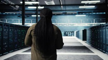 Veri Merkezi Sistem Yöneticisi siber tehditlere karşı güvenlik denetimleri yapar. Sunucu merkezi platformları arasında yürüyen bilişim uzmanı, endüstri standartlarına uymayı garanti ediyor, kamera A yakın çekim