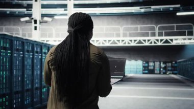 Engineer in server hub using laptop to upgrade rigs for increase in workload capacity using AI deep learning. Data center employee uses artificial intelligence to improve processing speed, camera A