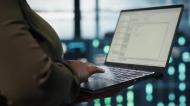 Veri merkezinde ağ altyapısını optimize etmek için çalışan yazılım geliştiricisini kapatın. Sunucu çiftliğindeki programcı cihaz kullanarak ekipman arızalarını tespit edip çözüyor