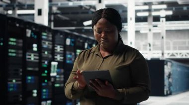 Veri merkezinde tablet kullanan teknisyen, yeni teknoloji ve sistemleri entegre ediyor. Çalışan sunucu merkezini denetlemek için aygıt kullanıyor, endüstri standartlarına uyulmasını sağlıyor, kamera B