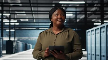 Veri merkezi yazılım geliştiricisi işlevsel etkinliği artırmak için tabletteki veri merkezi ölçümlerini izler. Sunucu odasında performansı tahmin etmek için uygulama aygıtı analizi kullanan kadın, kamera B