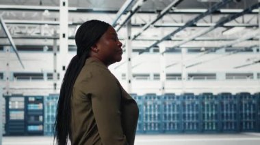Veri merkezinde yürüyen bir yönetici, kusursuz işlemleri sürdürmek için büyük ölçekli bilişim donanımını denetliyor. Artan çalışma süresi için ağ yönetimi yapan sunucu odası çalışanı, kamera B