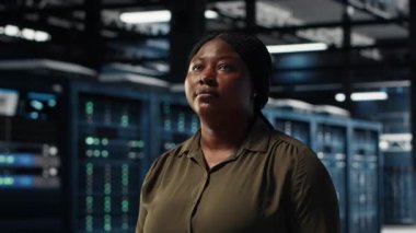 Portrait of cheerful data center engineer conducting security audits to protect against cyber threats. Jolly worker walking in server room, ensuring compliance with industry standards, camera B