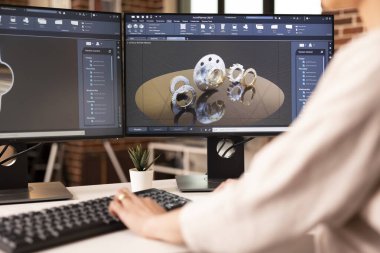 Kadın mühendis teknik planlamaya odaklanırken CAD yazılımında gösterilen 3D metal bileşenini kapat. Tuğla duvar daire yumuşak ışıklandırma, ve yapılandırılmış arayüz destek yeniliği ve doğruluk