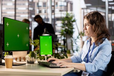 Young administrator reviewing company data next to copy space display, solving resource allocation to achieve effective business operations. Woman does financial forecasting and data analysis.
