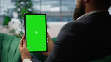 Strategic CEO in a global corporate setting holds mockup display reviews investment plans, evaluates market research and drives his business empire to greater success. Success story. Camera B.