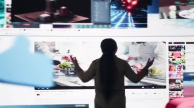 Relaxed woman entering world of online media, enjoying access to thousands of streaming videos. Entertained user surrounded by video previews highlighting diverse internet content, camera B