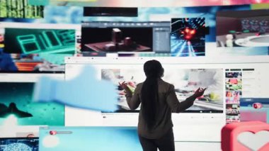 Kadın, modern sosyal medya ağlarının videolarını gösteren birbirine bağlı ekran kolajı izliyor. Kullanıcı, sabit hareketli içerikli verilerin görselleştirilmesine bakar, kamera A