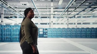 Veri merkezinde yürüyen bir yönetici, kusursuz işlemleri sürdürmek için büyük ölçekli bilişim donanımını denetliyor. Artan çalışma süresi için ağ yönetimi yapan sunucu odası çalışanı, kamera A