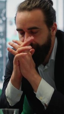 Vertical Video Male corporate leader buries his face in his hands due to frustration, pressure of a declining economy and battling the stress of a failing company. Business downfall and bankruptcy