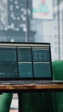 Vertical Video Big data reports and graphics showcasing business corporation success, empty luxurious office with a laptop on the table. Professional workspace with pc display running trends.