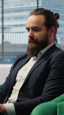 Vertical Video Confident businessman manages corporate expenses on laptop, determined professional in a corporate office reviews financial reports. Ensures a successful career and leadership skills