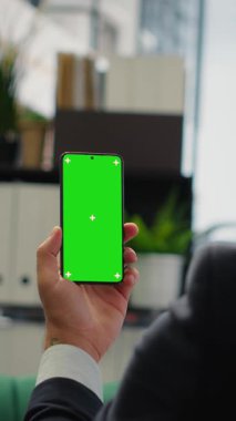 Vertical Video Strategic CEO in a global corporate setting holds mockup display reviews investment plans, evaluates market research and drives his business empire to greater success. Success story